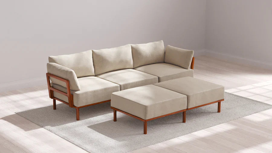 In a sunlit, minimalistic room with wooden flooring, an Indoor Jack 3-Seater Sofa in Balsa is arranged on a light gray rug. Two bench ottomans match in front of the sofa.