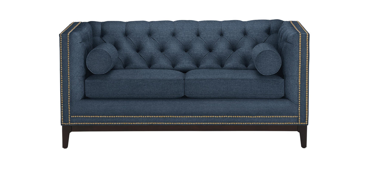 The Anderson Loveseat is a rectangular sofa in dark teal, featuring a tufted design with nailhead trim along the edges. It comes with two seat cushions and two cylindrical bolster pillows, all supported by dark wooden legs.