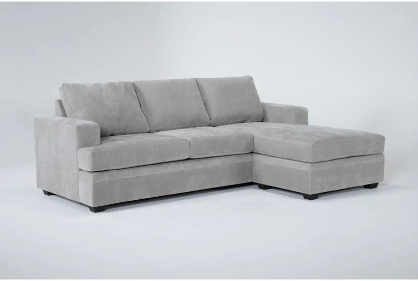 A Bonaterra 97 Inch Queen Sleeper Sofa, a modern gray sectional with plush cushions and armrests, includes a chaise lounge on the right side and is set against a plain white background.