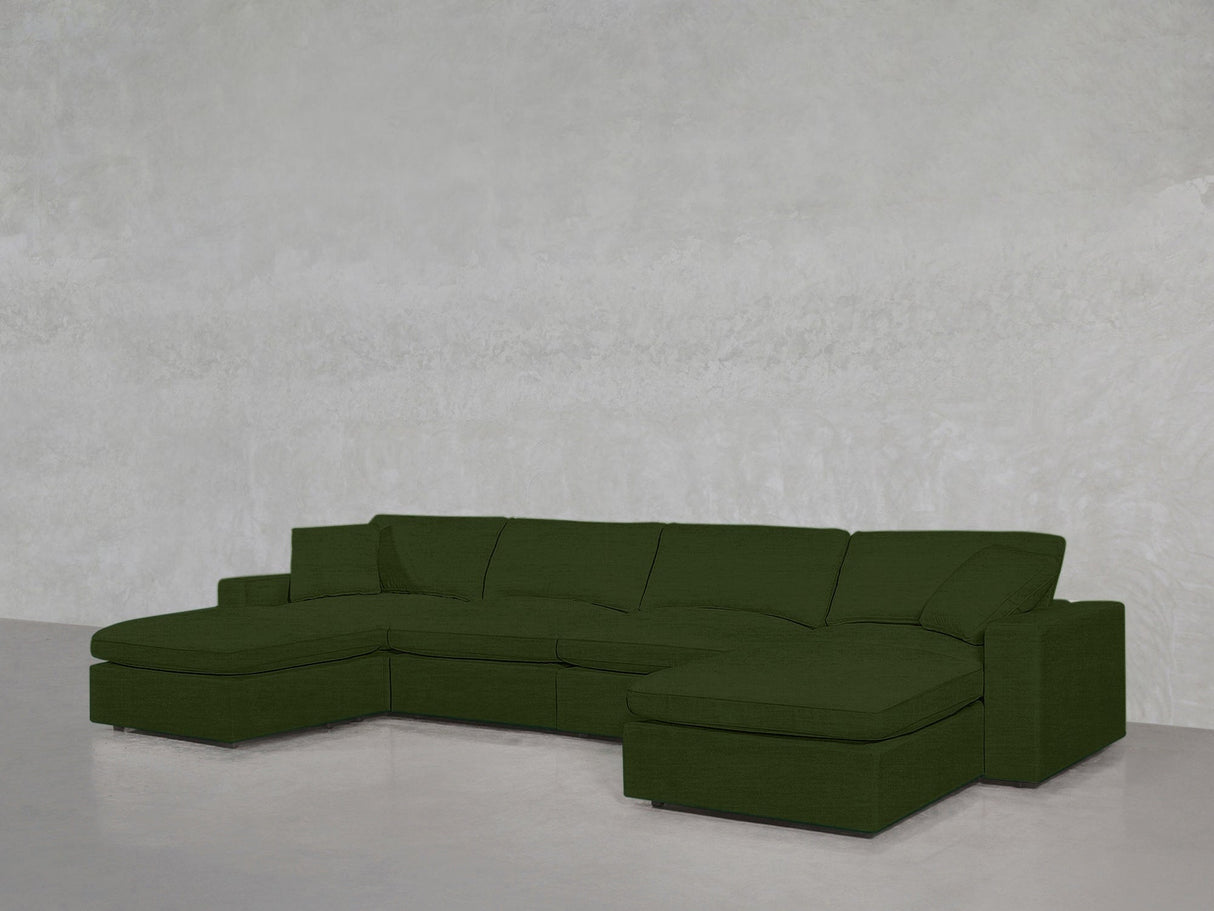 A 6-Seat Modular Double Chaise Sectional in green is placed against a plain, light gray wall and floor.