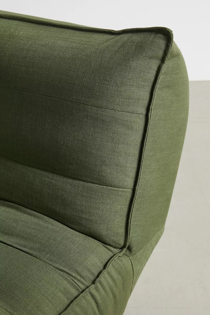 Close-up of the Greta XL Sleeper Sofa, a modern green fabric piece featuring a cushioned backrest and detailed stitching, set against a light gray background.