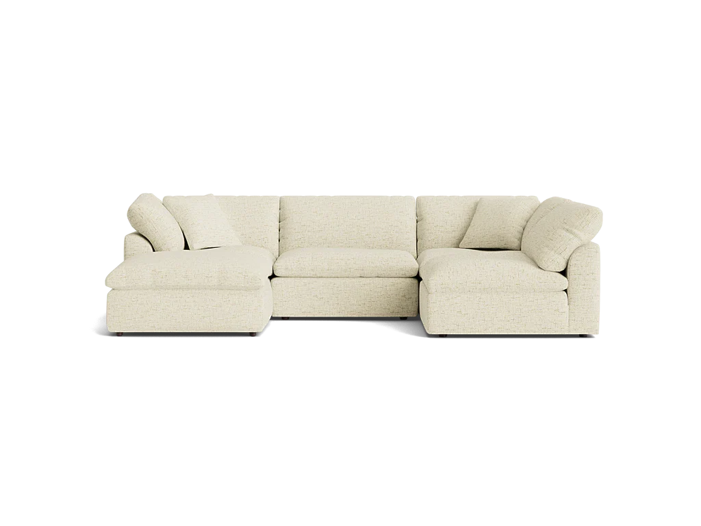 The Bryant U-Sofa Bumper Sectional, a beige L-shaped sofa with cushioned seats and backrests, is placed against a plain black background. This inviting and comfortable design is ideal for a modern living room.