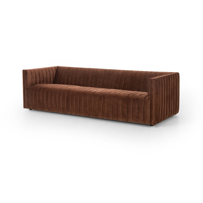 The Brandt 97'' Upholstered Sofa is a modern piece featuring a rectangular shape with vertical tufted lines, angled armrests, and a minimalist design in brown velvet, set against a white background.