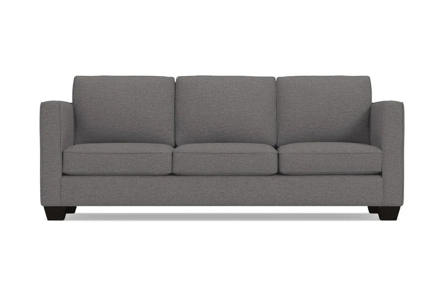 The Catalina Sofa is a stylish grey three-seater featuring square arms and dark wooden legs, all displayed against a plain white background. Its clean lines and modern design make it a chic addition to any space.