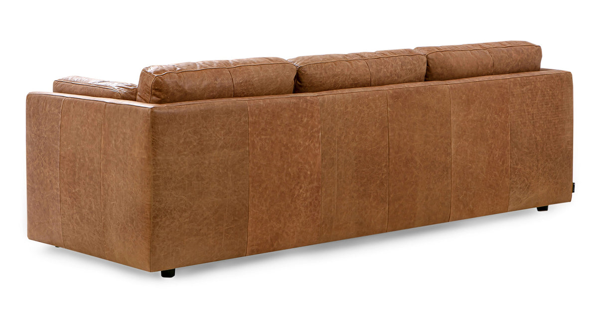 The Domus 93" Leather Sofa in Chestnut is displayed from the back, showcasing its smooth texture and three cushioned backrests. The modern design rests on small, barely visible legs against a plain white background.