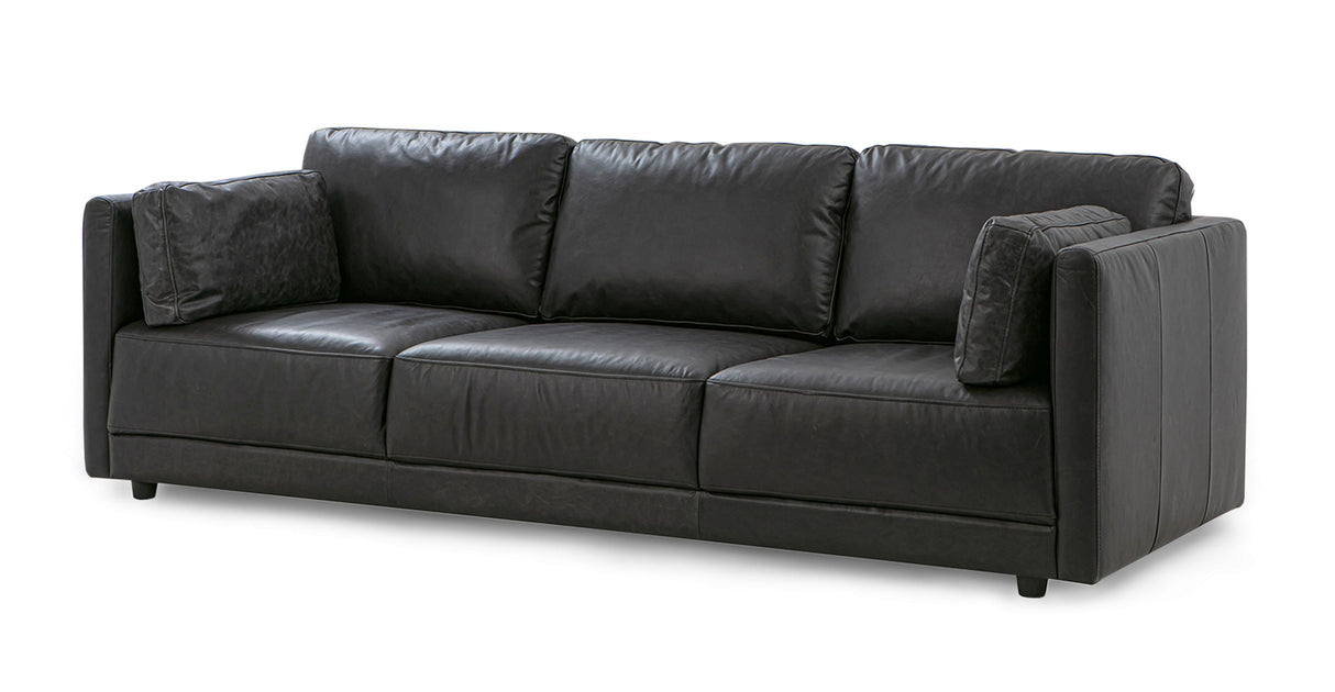 The Domus 93" Leather Sofa, Chestnut is a sophisticated piece featuring three seat cushions with matching back cushions. Its modern design includes square armrests and it comes with two decorative pillows on each end for added style.