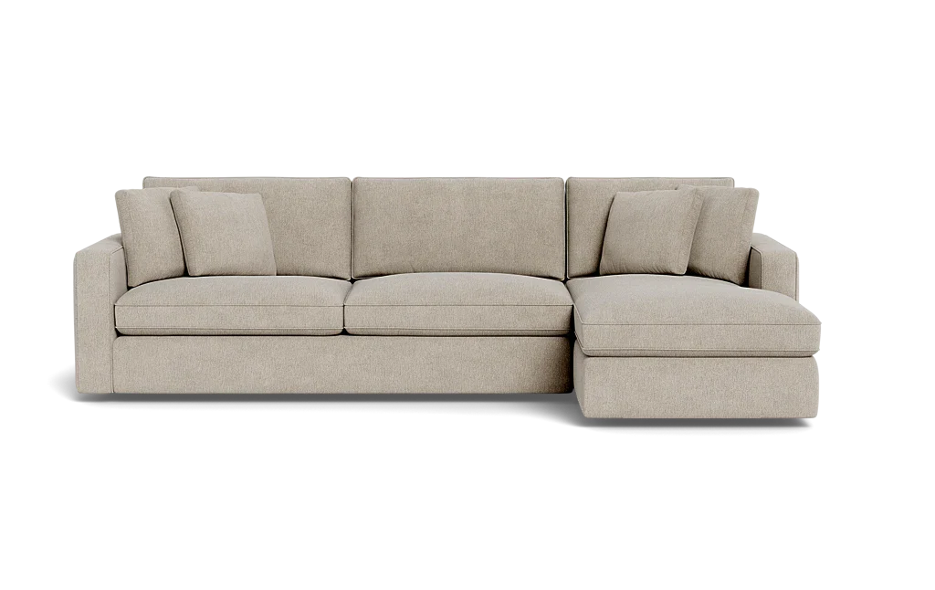 The James 3 Seat Left Chaise 92" Sectional is a beige sectional sofa featuring three seat cushions and an attached chaise on the left. It comes with three matching throw pillows, providing a clean and modern design.