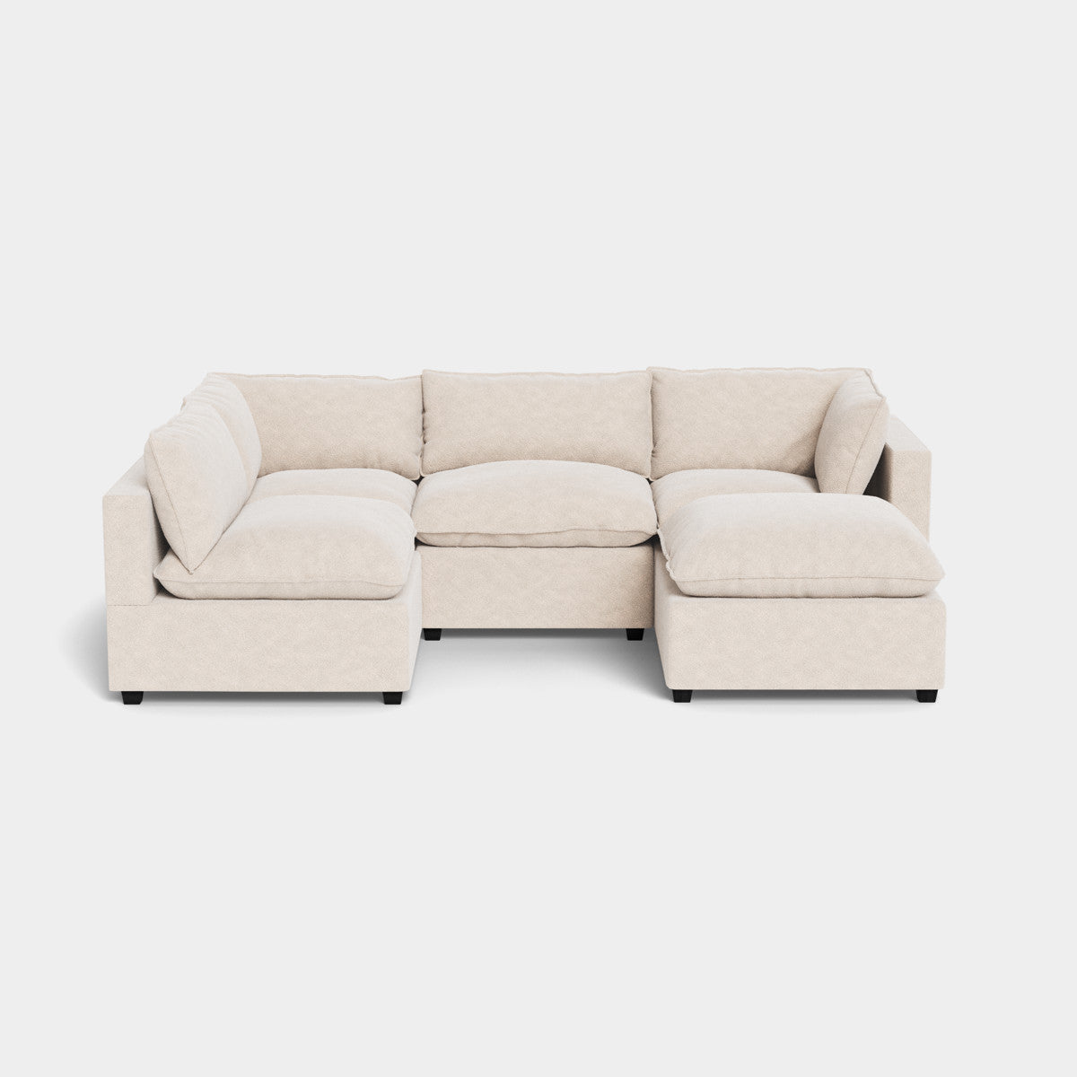 Kova L Shape sectional with ottoman, featuring plush cushions, set against a plain white background.