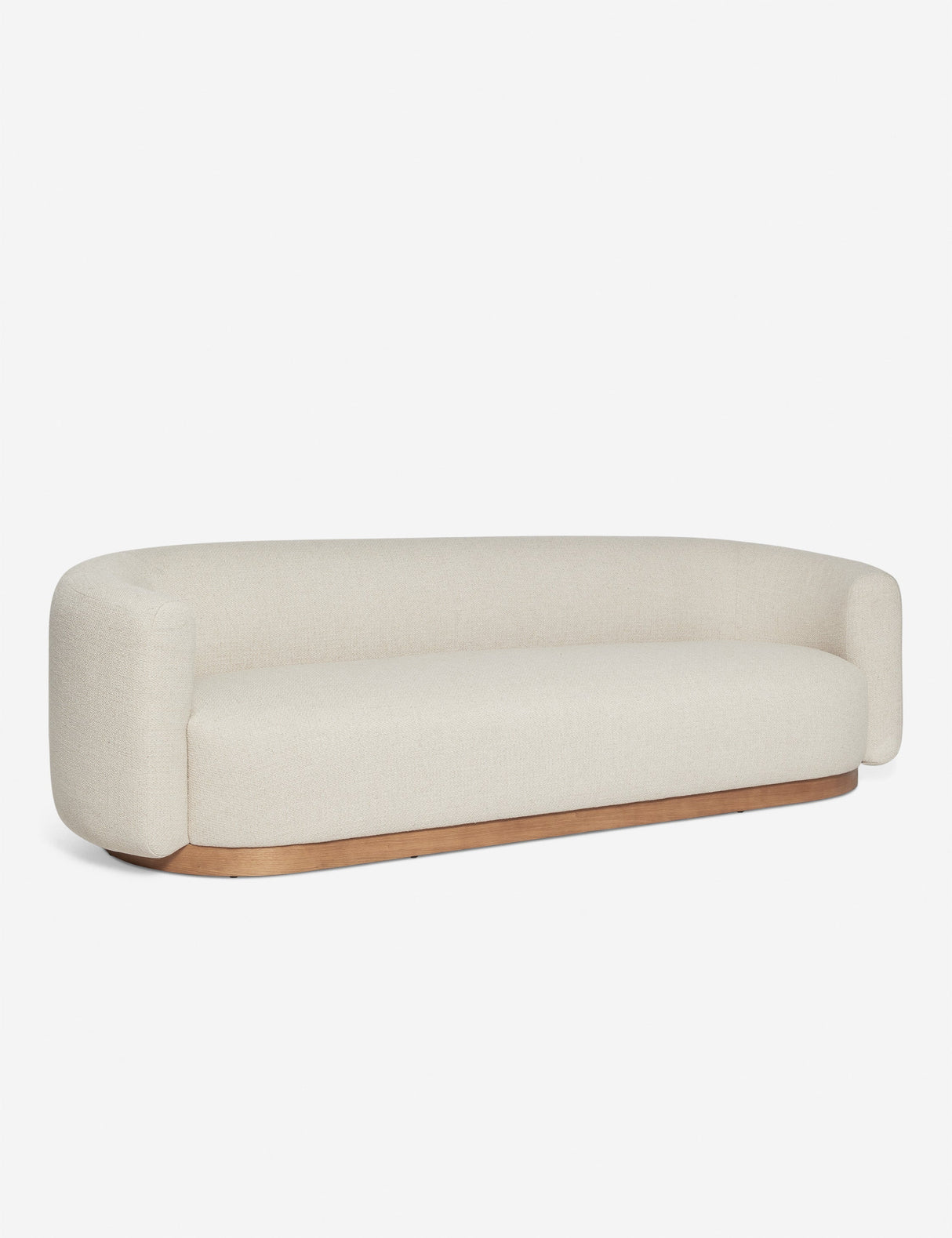 The Lowry Sofa, featuring a minimalist beige design with rounded edges and a wooden base, is showcased against a plain white background. It boasts a modern, streamlined look with cushioned armrests and a smooth, continuous back.