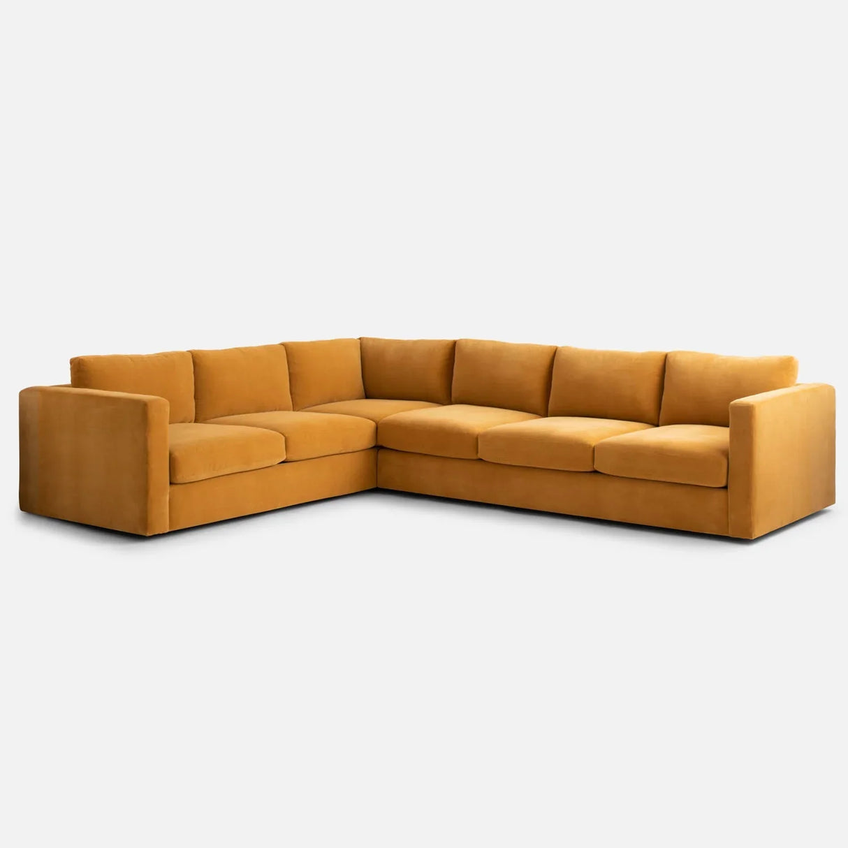 A Milo Sectional in a mustard yellow color featuring plush cushions and a modern L-shaped design, set against a plain white background.
