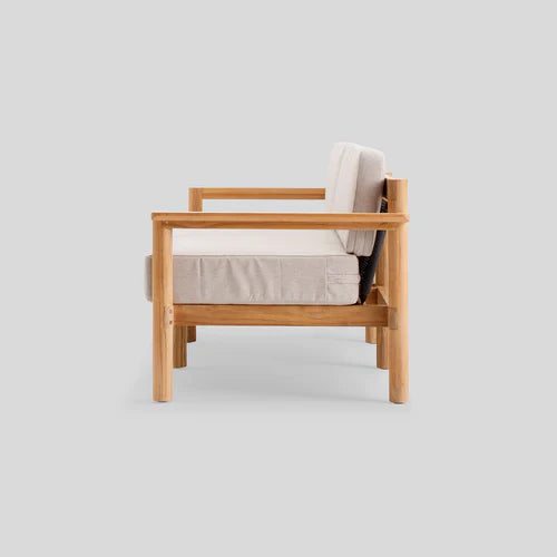 Side view of the Haven Sofa with a sturdy wooden frame and minimalist design, featuring beige cushions, set against a plain gray background.