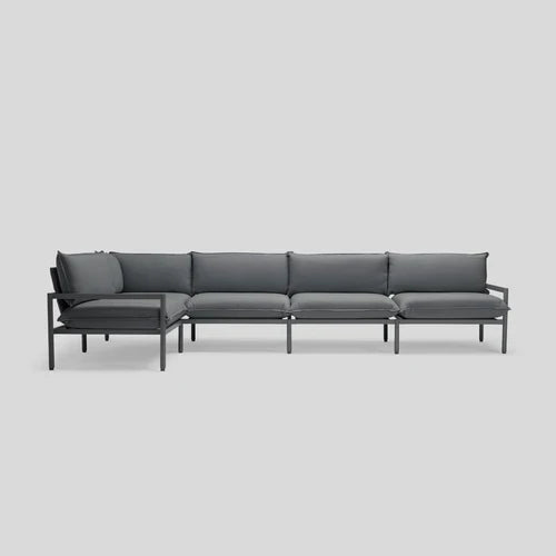 The Terra Sectional is a contemporary, minimalist sofa featuring a dark gray metal frame and coordinating dark gray cushions, designed in an L-shape against a light gray backdrop.