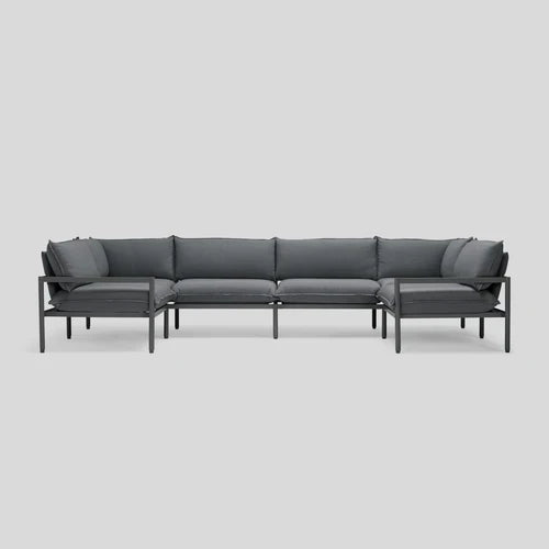 The Terra Sectional, characterized by its modern and minimalist design with a dark gray hue, metal frame, and cushions, is showcased against a plain light gray background.