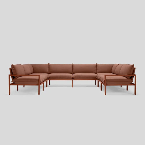 The Terra Sectional is a minimalist brown L-shaped sofa featuring a wooden frame and plush cushions, set against a plain gray background.