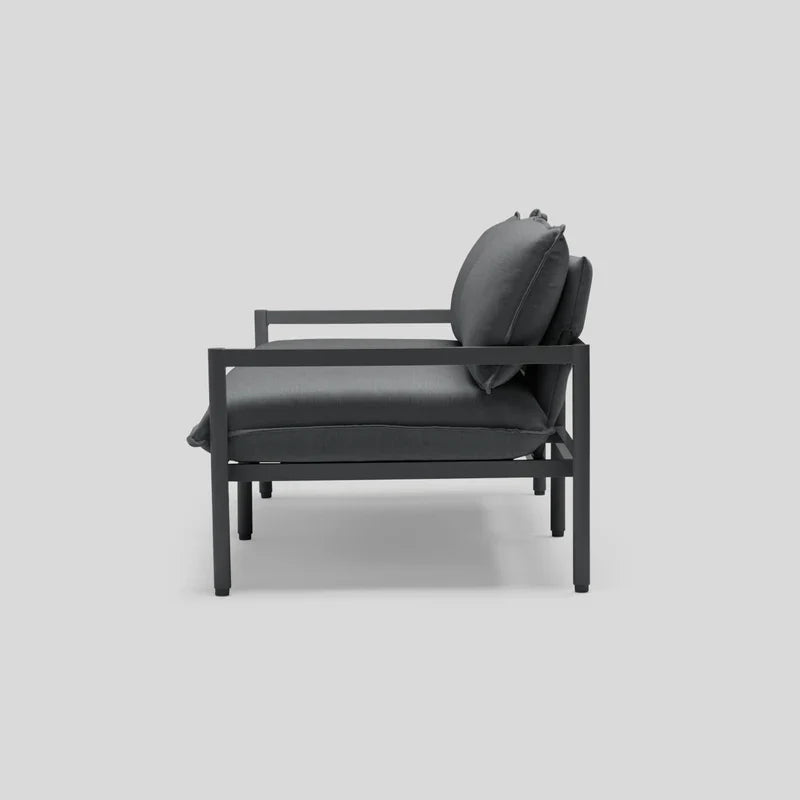 The Terra Loveseat, featuring a minimalist design with a dark gray color scheme, showcases its metal frame and cushioned seat and backrest from the side against a light gray background.