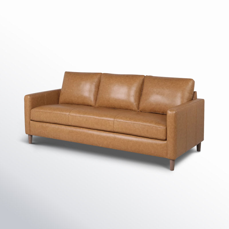 The Portland 80.5" Leather Sofa in tan leather features three cushions and sleek armrests, with wooden legs beautifully set against a light gradient background.