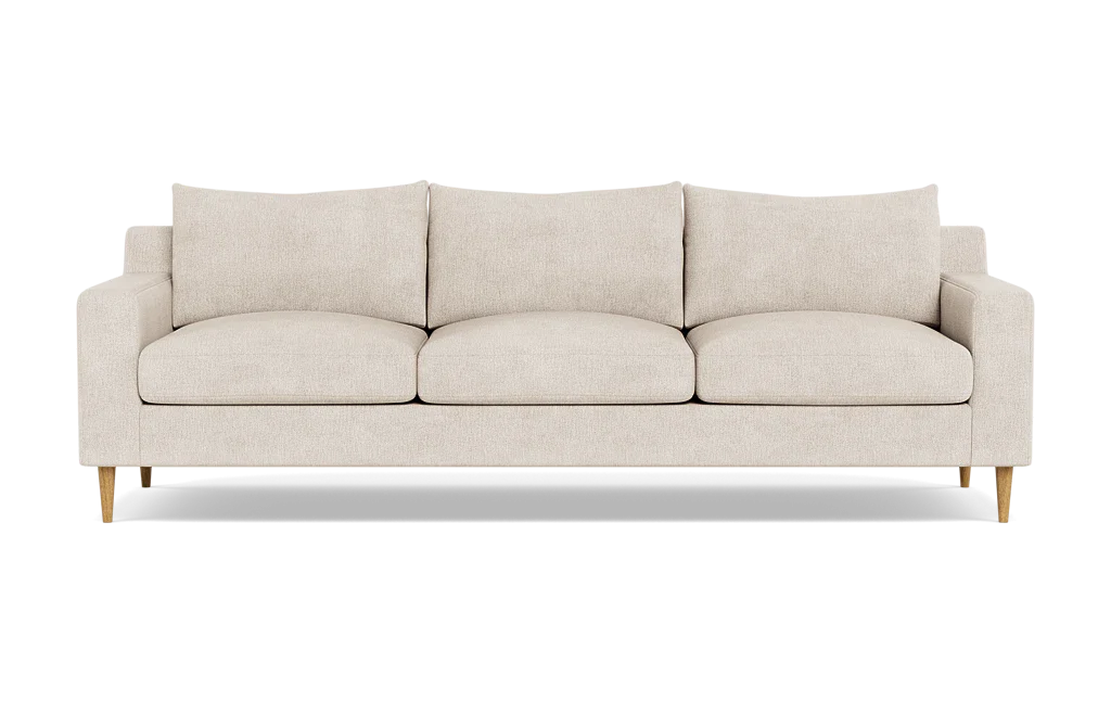 The Sloan Custom 3-Seat 95" Sofa features a beige color with a minimalist design, characterized by its clean lines, three cushions, and wooden legs, photographed against a plain black background.