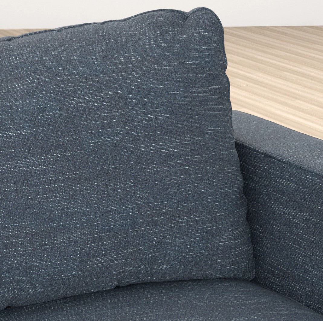Close-up of the Sactionals - 2 Seats + 4 Sides in Vintage Blue Rained Chenille, showcasing its textured fabric. The image highlights a corner section with a large cushion and armrest, set against light wood flooring.