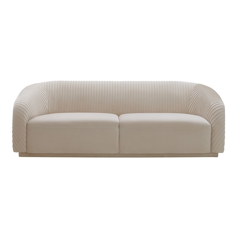 Introducing the Yara Pleated Velvet Sofa by Inspire Me! Home Decor, featuring a chic design with a rounded backrest and ribbed upholstery in a cream color. This sofa exudes a minimalist, contemporary aesthetic and is showcased against a stark white backdrop.