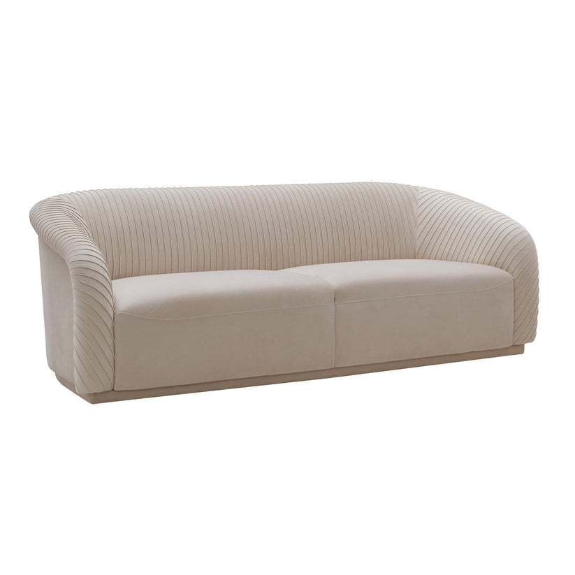 Introducing the Yara Pleated Velvet Sofa by Inspire Me! Home Decor: a beige, modern piece featuring curved arms and a ribbed backrest design. This sofa boasts a sleek, minimalist aesthetic on a flat base, perfect for contemporary living spaces.