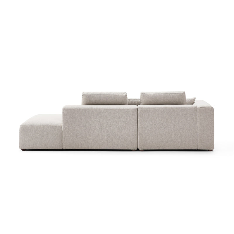 The 5th Open 116" Left Facing Sectional, a minimalist beige sofa viewed from the back, boasts three back cushions and a clean, modern design with straight lines, set against a plain white background.