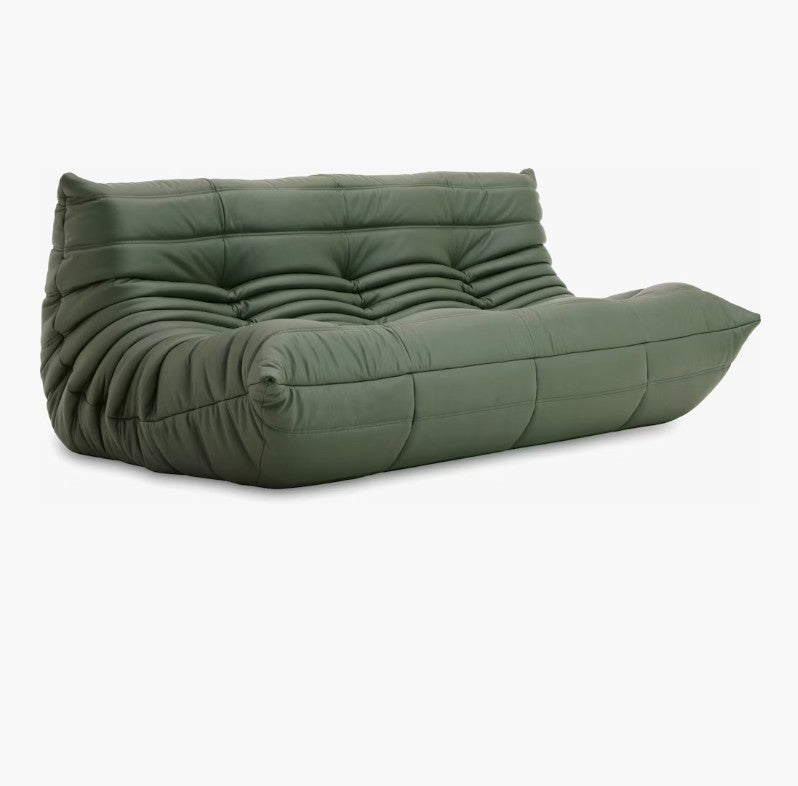 A Togo Sofa in Opera Leather, featuring a tufted design with a low profile and soft, rounded edges, upholstered in green leather or a similar material, set against a white background.