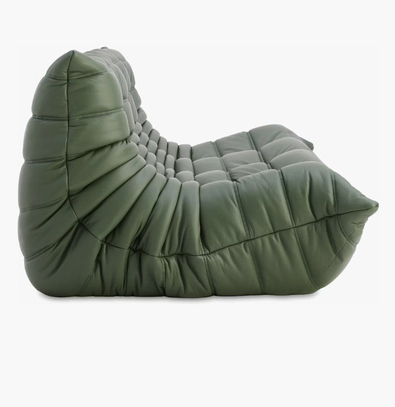 The Togo Sofa in Opera Leather, featuring a modern design with tufted detailing and an armless structure, is highlighted on a white background, exuding a sleek and contemporary style.