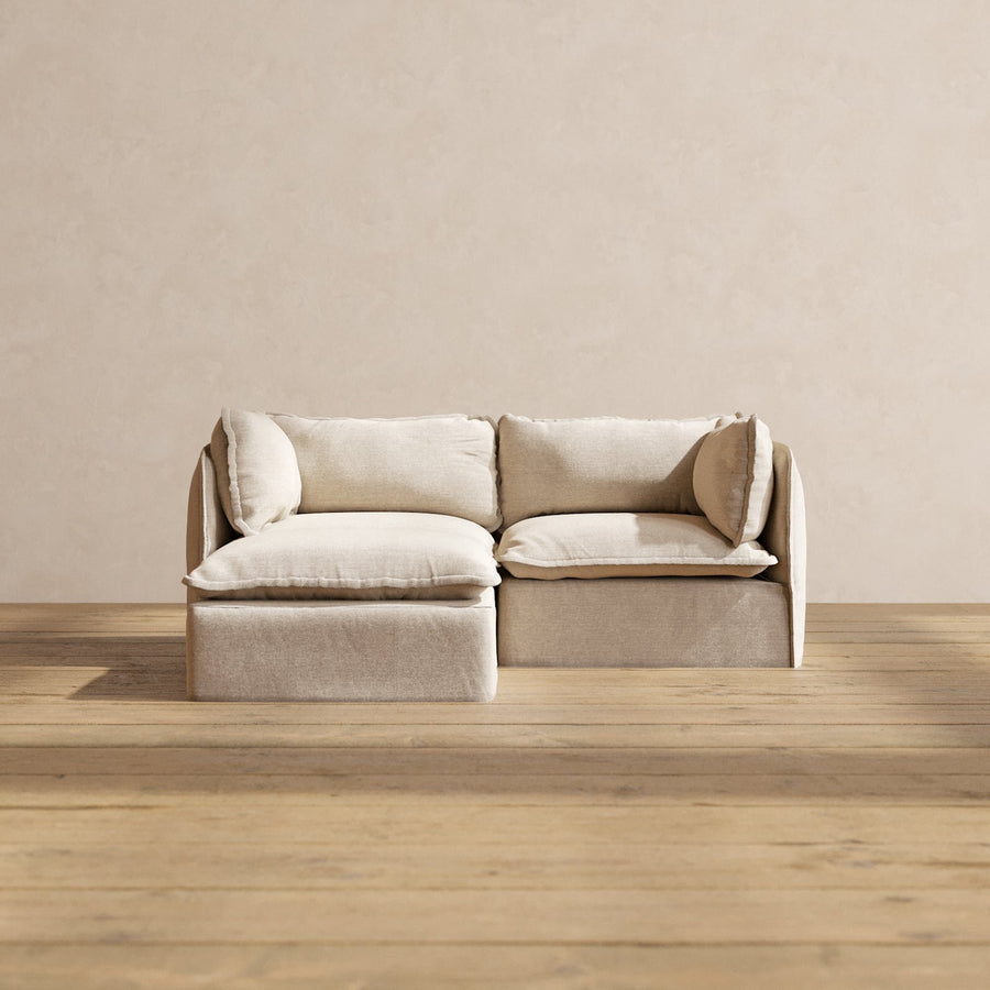 The Modular Performance 2-Seater Sectional with plush cushions is set against a neutral wall on a wooden floor.