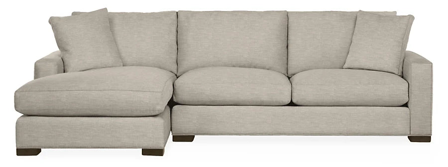 The Metro Sofas with Chaise is a light gray sectional featuring a left-side chaise lounge, modern design, three back cushions, and square armrests. It sits on short, dark wooden legs for an elevated look.
