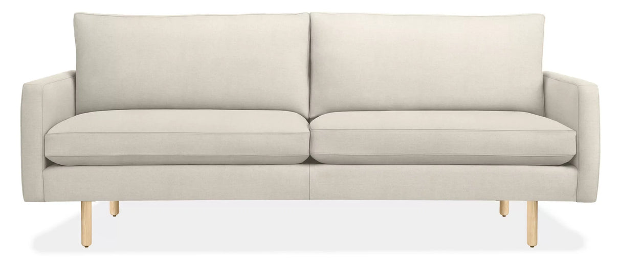 The 86" Jasper Sofa features a sleek and minimalist design, showcasing a light beige hue, two cushions, and oak wooden legs. It is viewed from the front in a modern style.