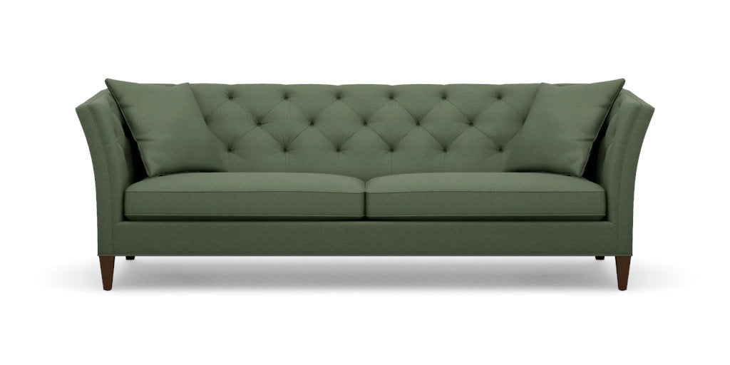 Introducing the Shelton 98" Sofa: This green, tufted sofa includes two seat cushions and two back pillows. It showcases a modern design with tall, angled armrests and tapered wooden legs.