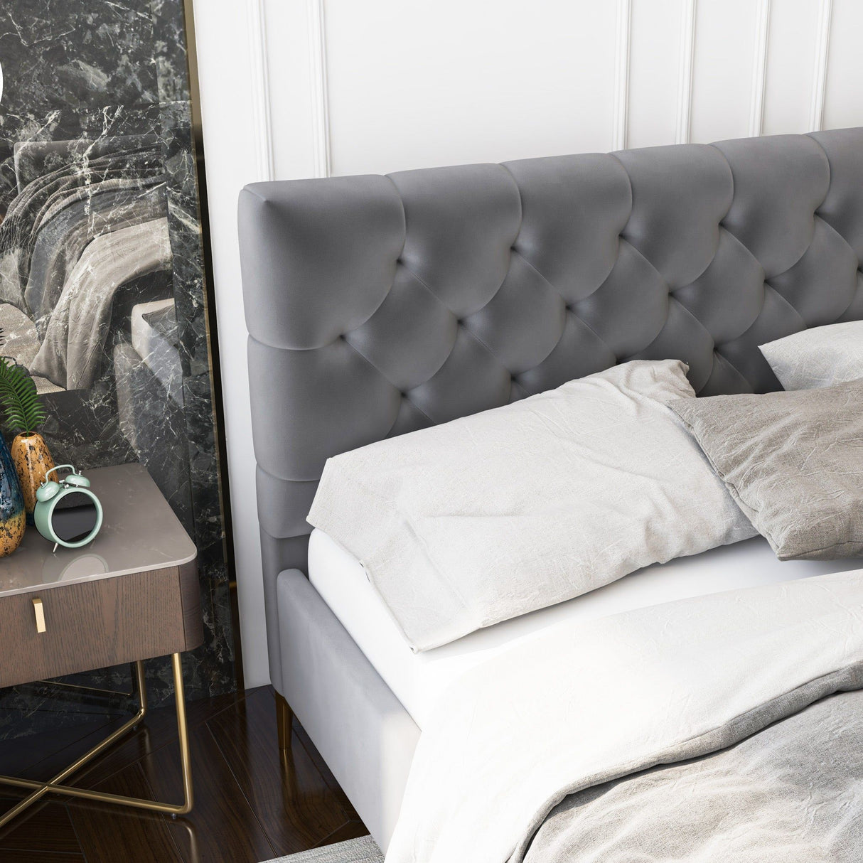 The Bailey Elegant Design Bed with gray tufted headboard is beside a wooden bedside table holding a green plant, alarm clock, and book. The room showcases a marble accent wall and hardwood flooring.