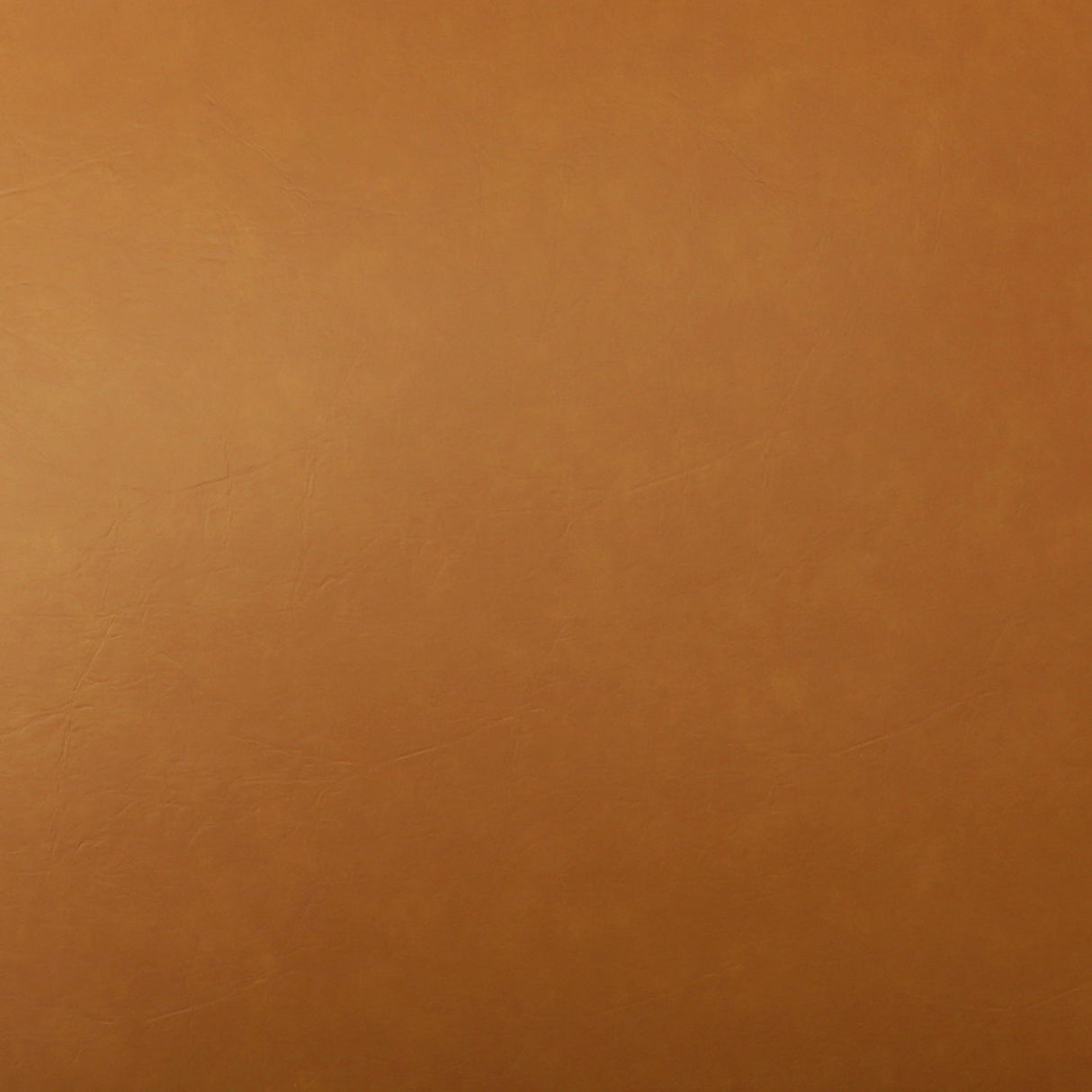 The Callan Swivel Chair in Tan features a brown textured leather surface with subtle variations and natural patterns, offering a smooth texture and earthy tone that exude a warm, rustic appearance.