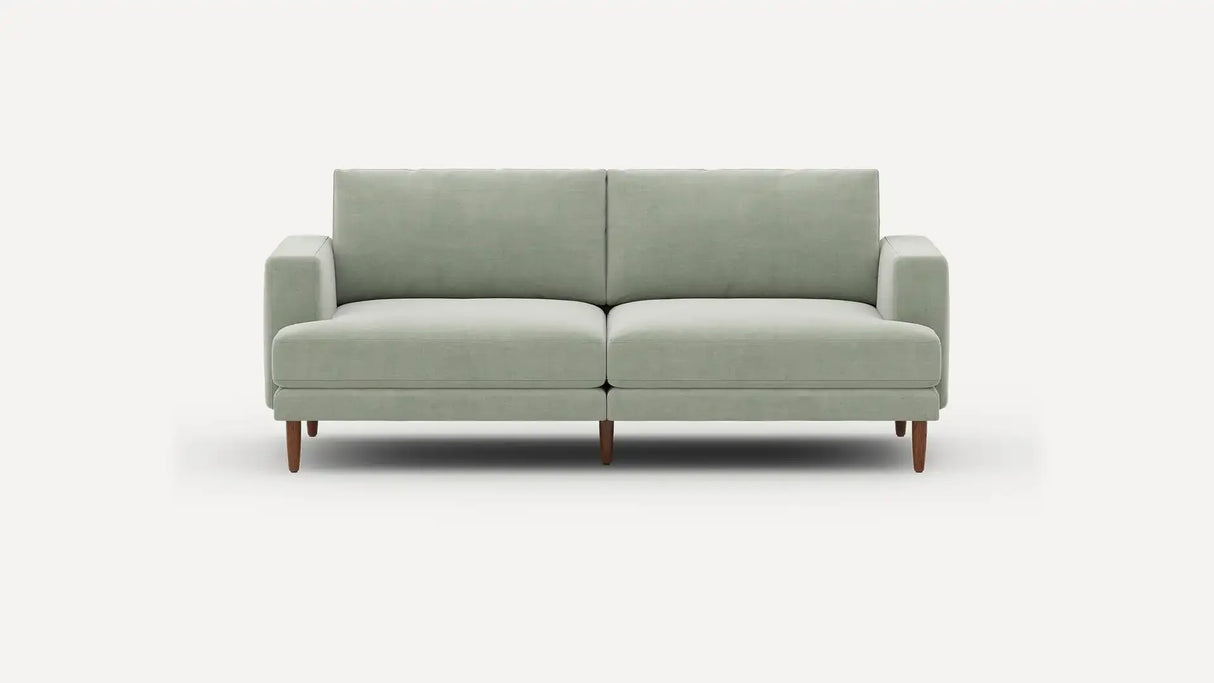 The Ember Mid-Century Modern 75" Sofa, featuring a light gray design with clean lines and wooden legs, is showcased against a plain white background.