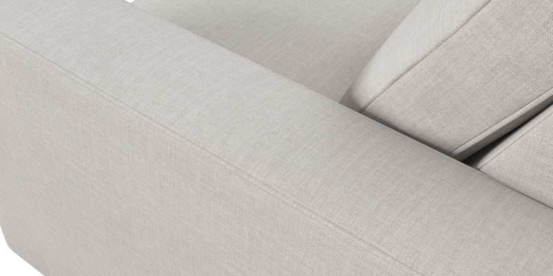 Close-up of the Rio Sofa, showcasing its light gray fabric with clean lines and visible stitching. The image highlights the armrest and backrest, emphasizing the texture and minimalist design of its upholstery.