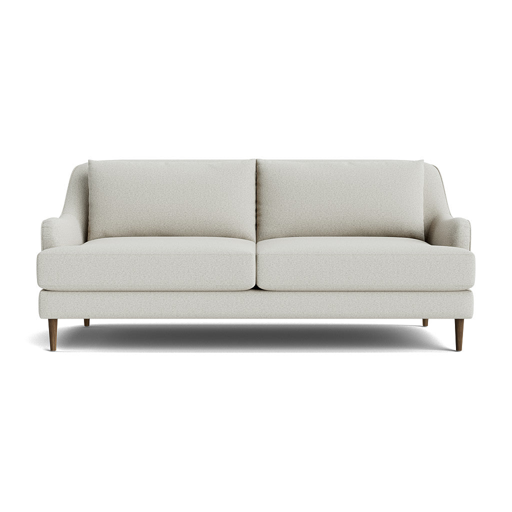 The Kaydan Sofa is a modern light gray piece with a minimalist design, featuring two seat cushions and two back cushions. It includes slightly angled armrests and stands on short, tapered wooden legs, set against a plain white background.
