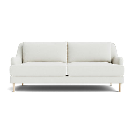 The Kaydan Sofa features a minimalist design in beige, accompanied by two cushions and sleek, light wooden legs, all set against a plain white background.