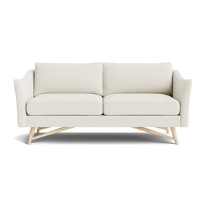 Introducing the Gio Sofa in Natural Latex: a contemporary white sofa boasting a minimalist design with two seat cushions and two back cushions. This elegant piece features sleek armrests and an angular wooden base, all beautifully showcased against a plain white background.