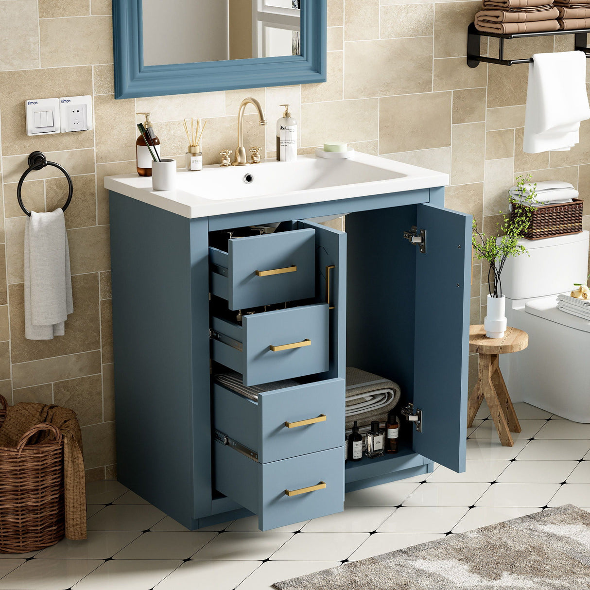 The bathroom scene showcases a Ceramic Sink Combo freestanding vanity set with open drawers revealing towels. It features a white countertop, modern sink, and faucet. Nearby are a woven basket and wooden stool, with towels on a wall shelf against neutral tiled walls.