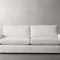 The Kipton 84" Deep Sofa, featuring a sleek and modern design with clean lines, is showcased against a plain, light gray background. Its minimalist white color and plush cushions contribute to its contemporary style.