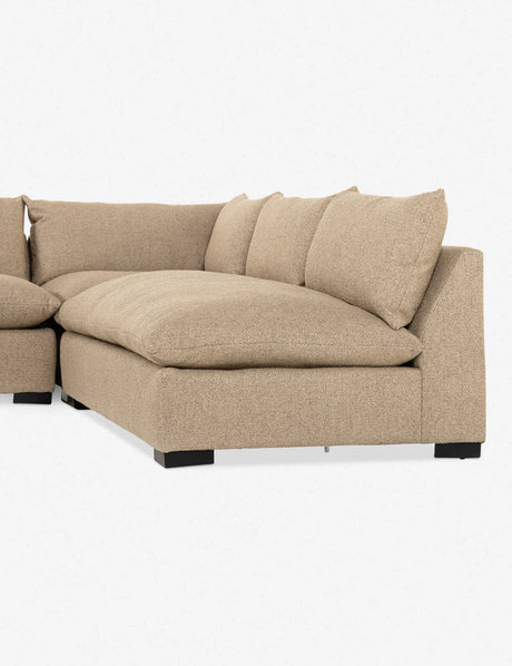 The Decima Sectional Sofa, featuring a modern design with thick cushions and a low backrest, is upholstered in beige fabric. It is positioned against a plain white background and stands on black wooden legs.
