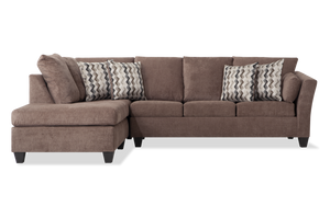 The Virgo Charcoal 119'' 2 Piece Chaise Sectional features an L-shape design with plush cushions and matching chevron-patterned throw pillows. It has wooden legs and provides ample seating space, perfect for a comfortable and modern living room setup.