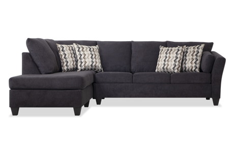 Introducing the Virgo Charcoal 119'' 2 Piece Chaise Sectional, a stylish dark gray sectional sofa featuring three spacious seats and a left-facing chaise lounge. It comes with four decorative pillows, showcasing an elegant chevron pattern in shades of gray and white.