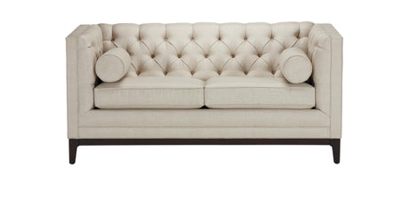 The Anderson Loveseat features a beige tufted design with two seat cushions and two bolster pillows. It has a high back and sides, supported by dark wooden legs.