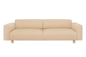 The Koti 3-seater Sofa in beige features a modern design with a low back and wide armrests against a white background. Its clean lines and minimalist aesthetics contribute to its contemporary appearance.