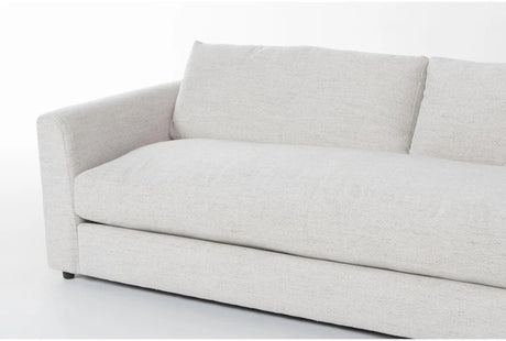 The Thea Down 101 Inch Beige Chenille Sofa is depicted with a minimalist design, showcasing a plush, light gray color. It includes a single seat cushion and two large back cushions against a plain white background, featuring a low-profile armrest on one side.