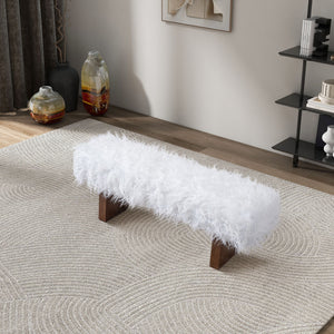 The Henley - Fur Bench in White Khaki, with its fluffy design and wooden legs, is positioned on a textured rug. Nearby are a shelf and two decorative vases, creating a modern living room setup.