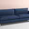 The Bowen 91" Sofa, featuring a modern design with two large seat cushions and backrests, is set against a soft beige background. The sofa comes in dark blue and is complemented by sleek, gold legs for a minimalist look.