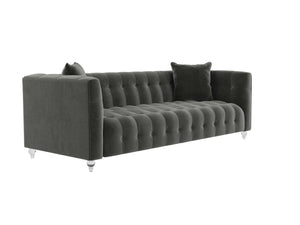 The Bea Velvet Tufted Sofa in dark green comes with two matching cushions and is supported by clear legs. This sofa boasts a modern design with a high back and armrests, offering a plush and elegant appearance.