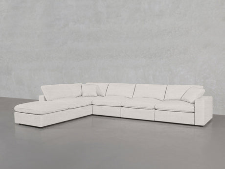 The 6-Seat Modular Corner Lounger Sectional features light beige fabric upholstery and a left-side chaise, shown against a plain light gray wall and floor.